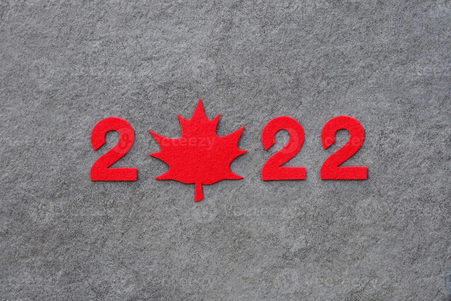 rosso provato nuovo anno numeri 2022 su buio grigio pietra superficie. zero nel il forma di un' rosso acero foglia come un' simbolo di Canada. revisione di il anno. foto