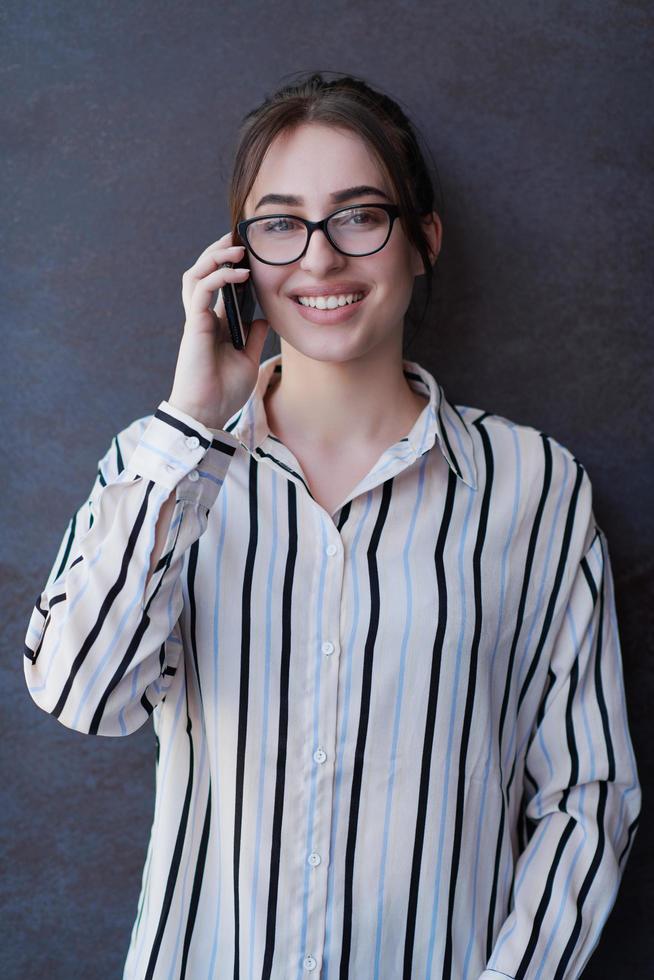 avviare donna d'affari nel camicia con un' bicchieri utilizzando mobile Telefono foto