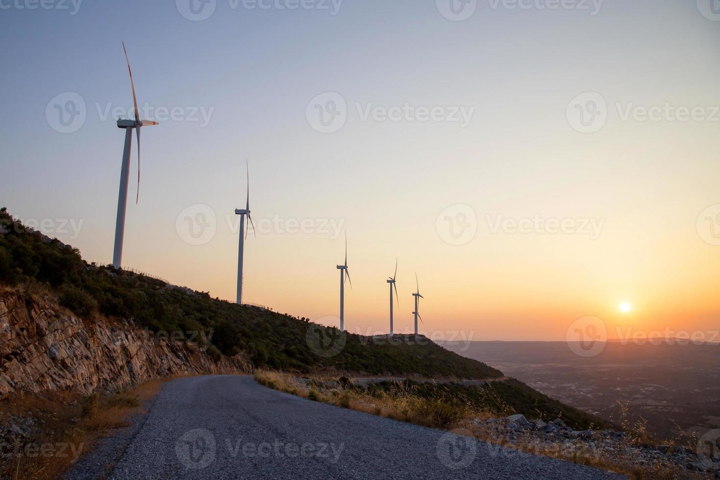 bel tramonto con sagome di turbine eoliche foto