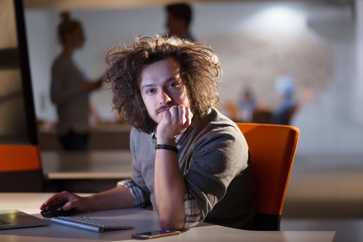 uomo Lavorando su computer nel buio ufficio foto