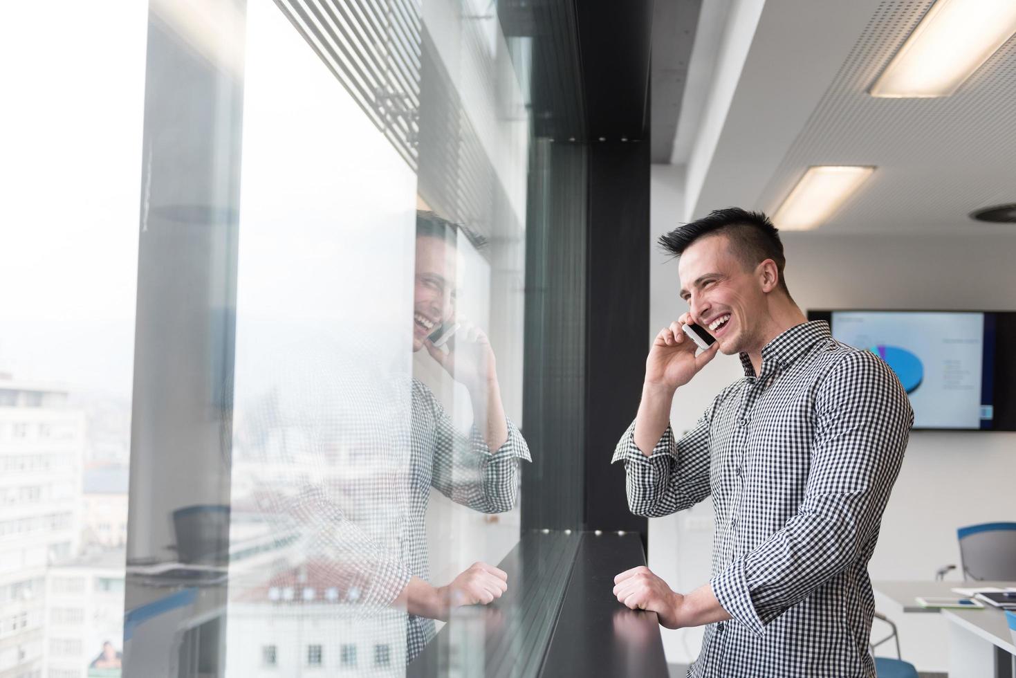 giovane attività commerciale uomo A proposito di su inteligente Telefono a ufficio foto