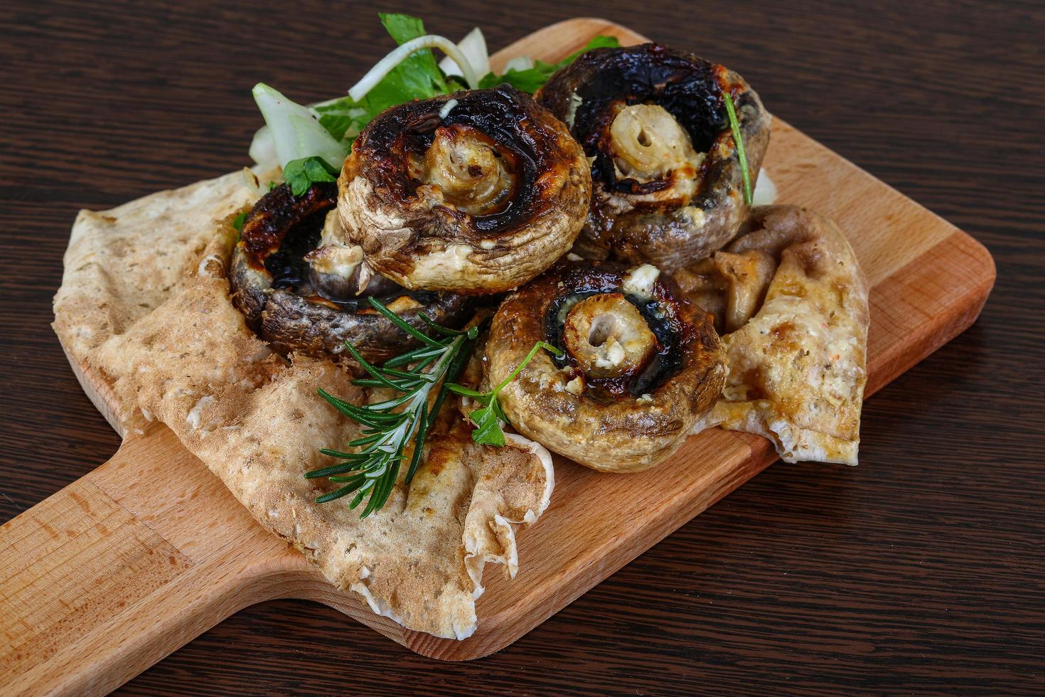 al forno champignons su di legno tavola e di legno sfondo foto