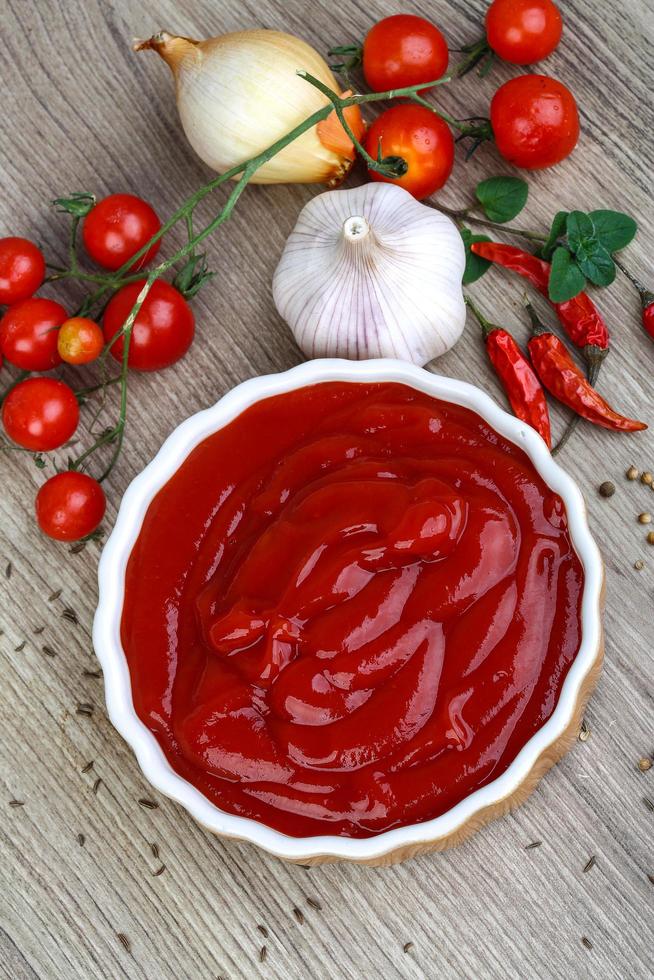 pomodoro ketchup nel un' ciotola su di legno sfondo foto