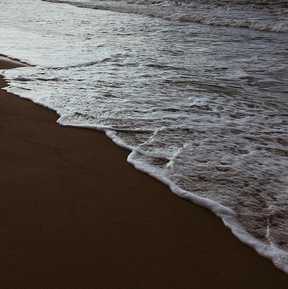 schiuma di mare sulla spiaggia foto