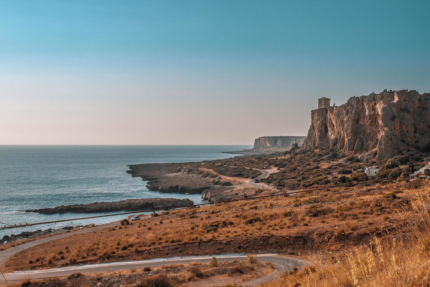 scogliera vicino al mare durante il giorno foto