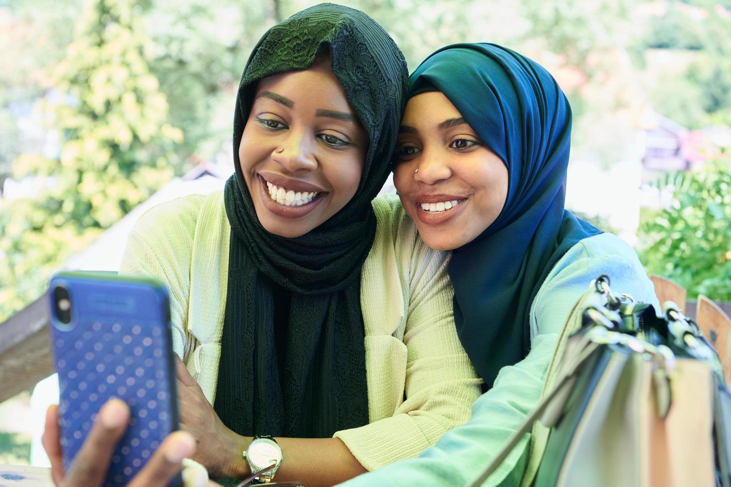 africano femmina amici utilizzando inteligente Telefono insieme foto