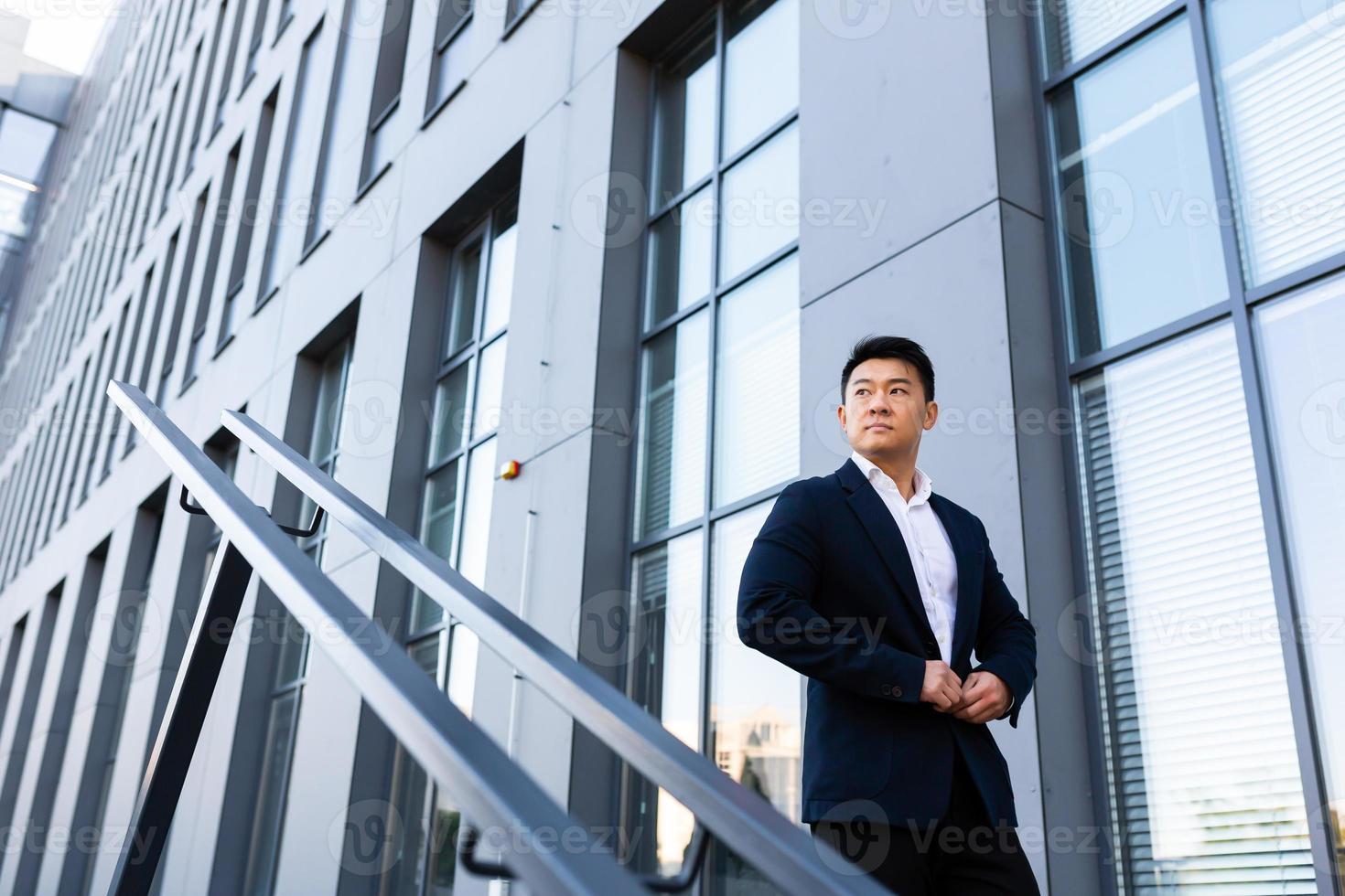 asiatico uomo d'affari passeggiate su il le scale di il ufficio centro, uomo si affretta per un' attività commerciale foto