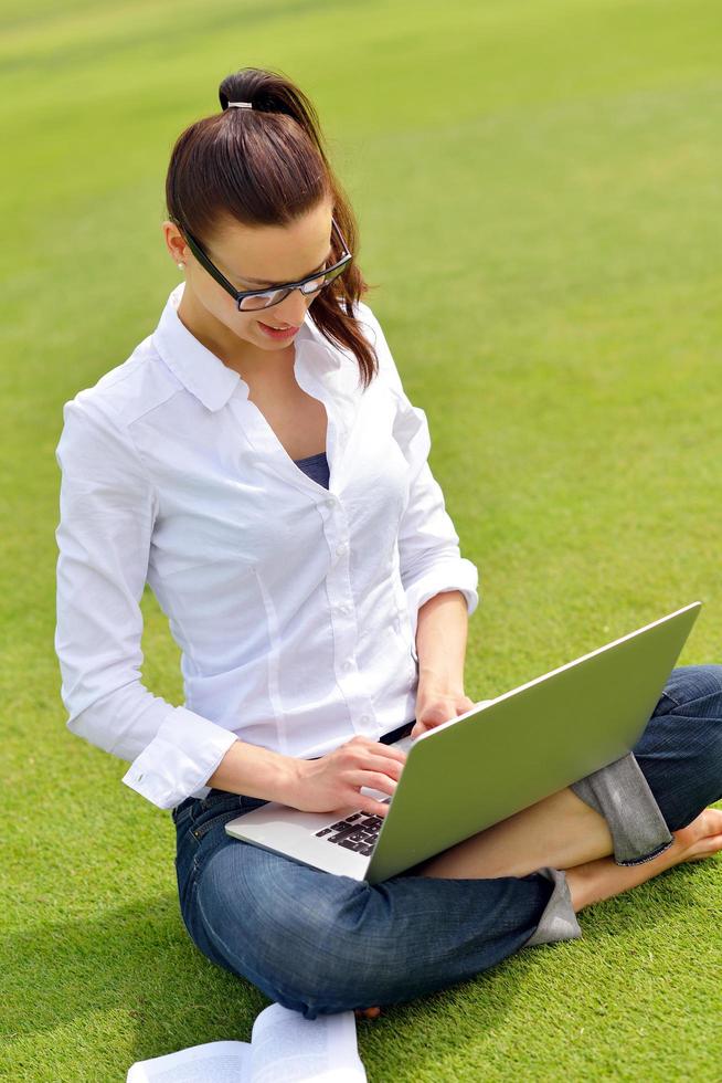 donna con il computer portatile nel parco foto