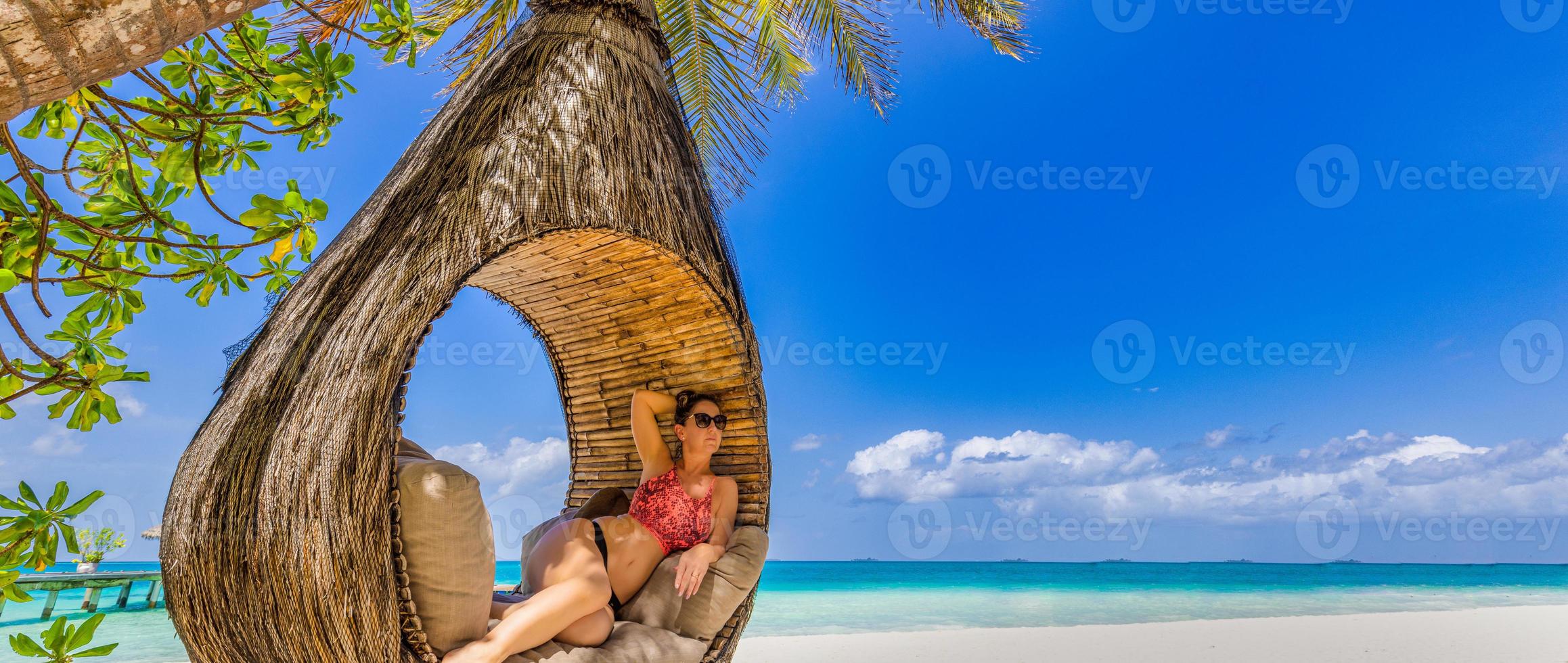 giovane bellissimo ragazza nel nero arancia bikini con lungo bionda capelli e occhiali da sole rilassante nel amaca su tropicale spiaggia. esotico panoramico paesaggio, Paradiso isola vacanza. spensierato, la libertà panorama foto