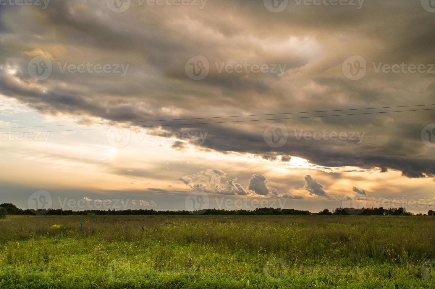 nuvoloso tramonto paesaggio nel un' campo foto