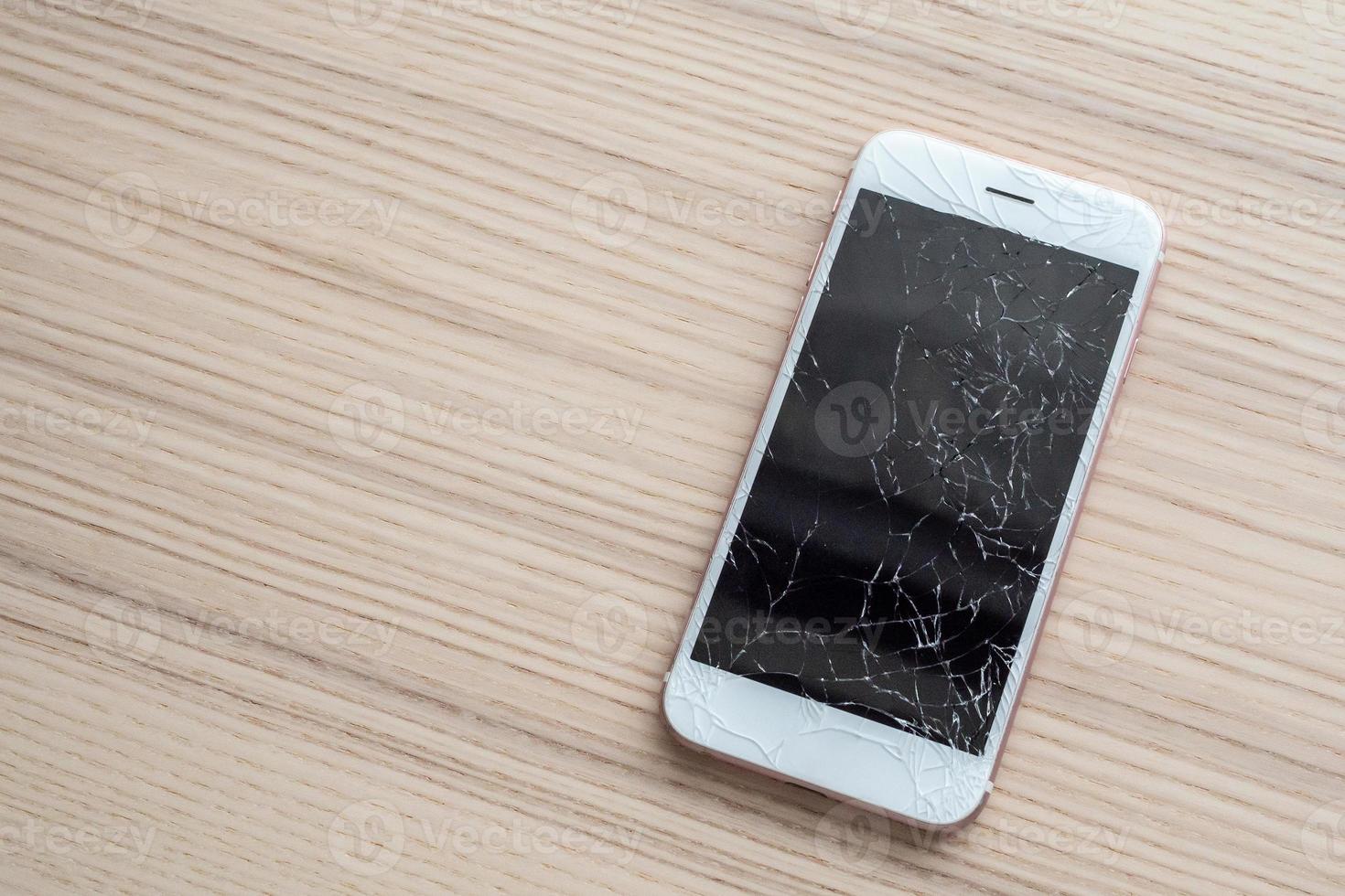 rotto bicchiere di mobile Telefono schermo su di legno sfondo foto