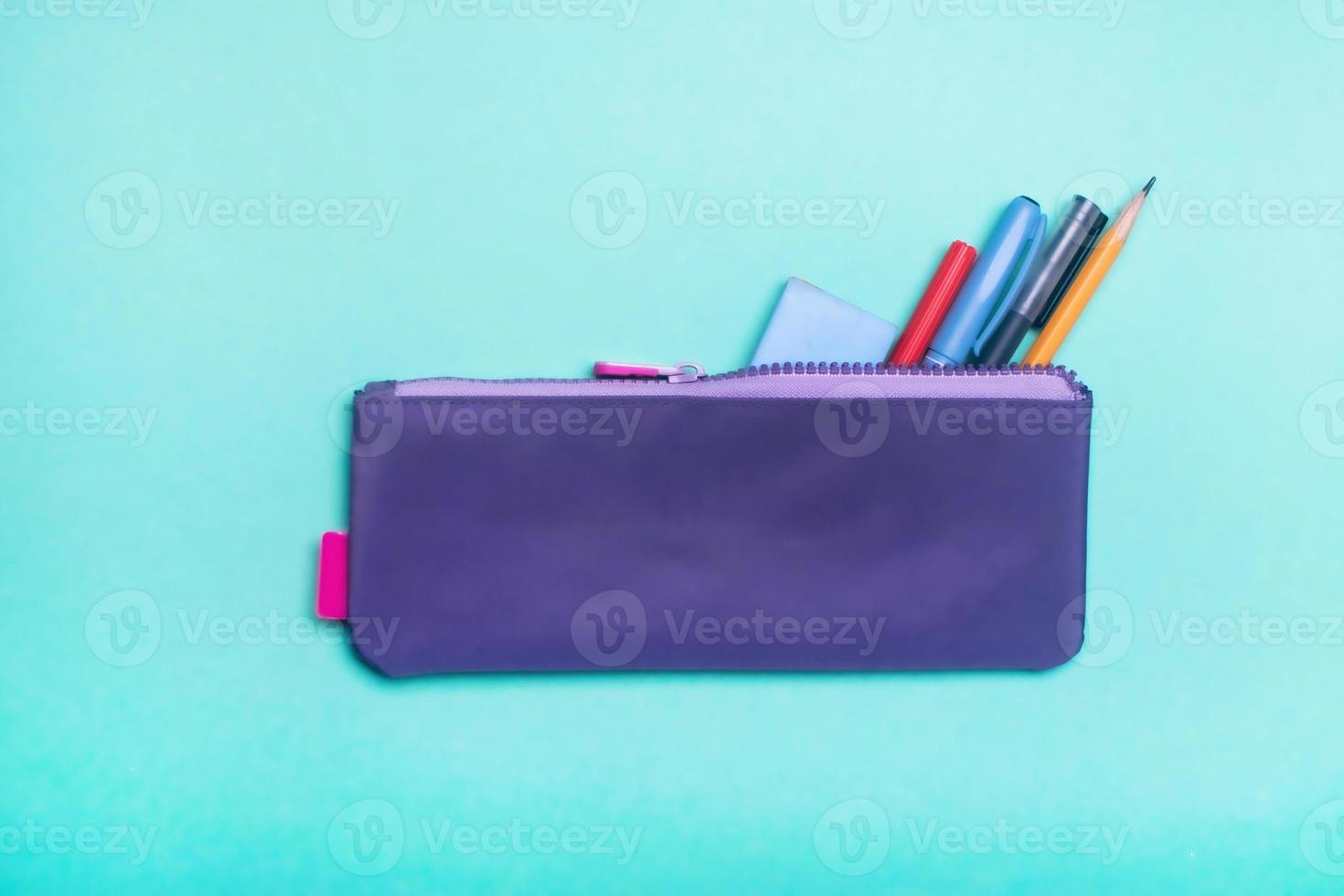 alla moda viola matita Astuccio con multicolore pennarello penne, matite e penne su verde sfondo. foto