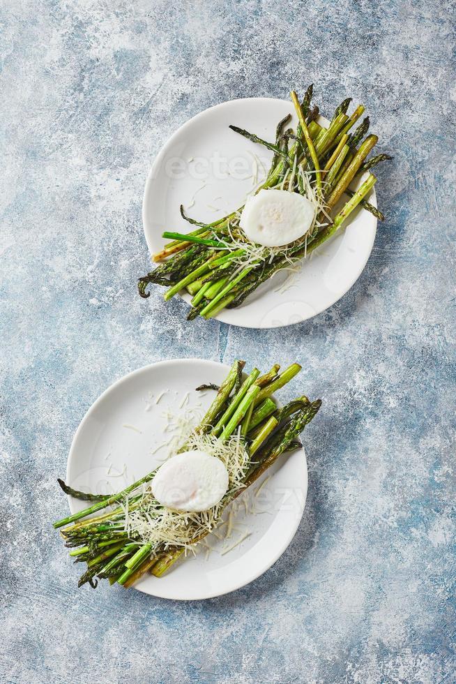 verde asparago con in camicia uovo e parmigiano, vegetariano prima colazione servito su bianca piatto foto