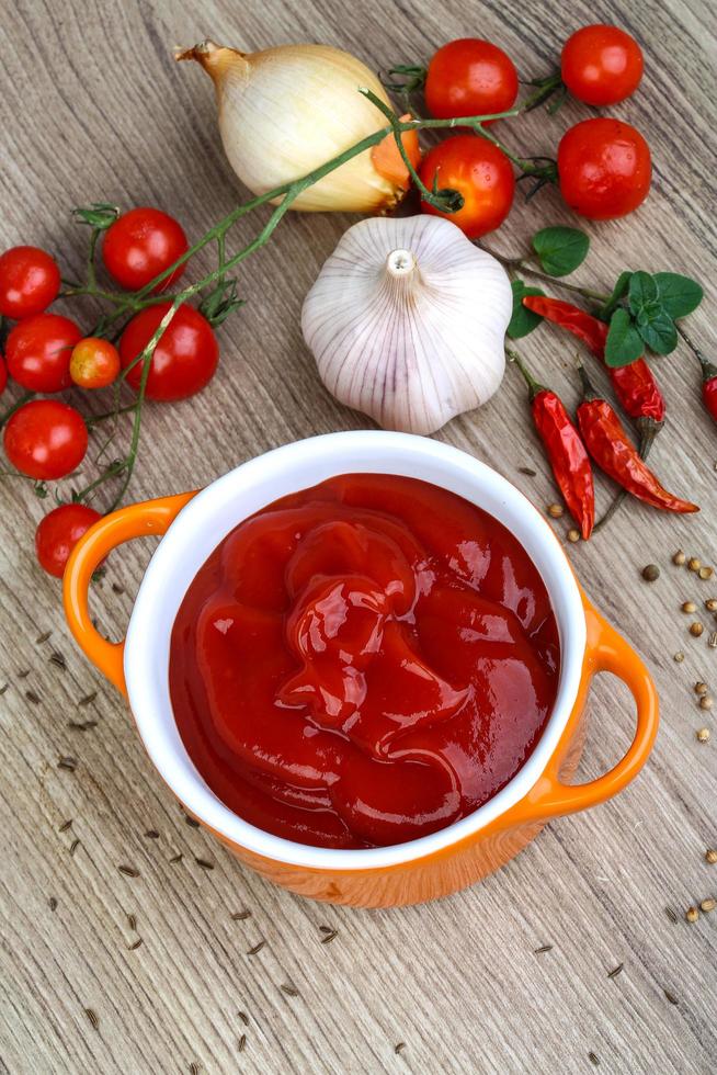 pomodoro ketchup nel un' ciotola su di legno sfondo foto