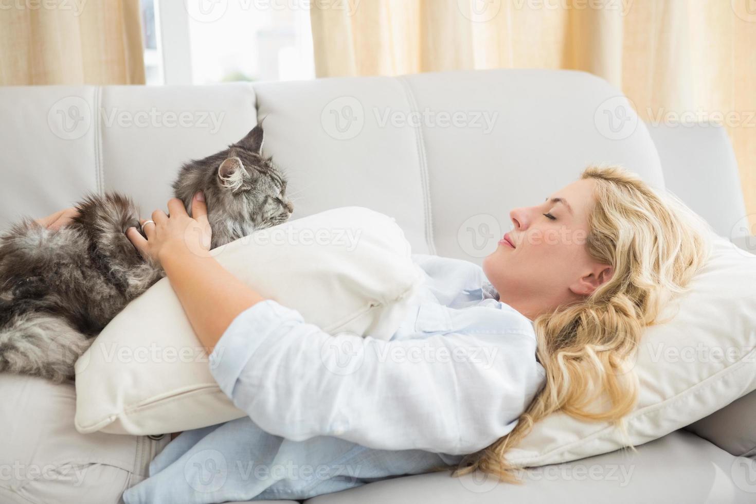 bionda felice con gatto domestico sul divano foto