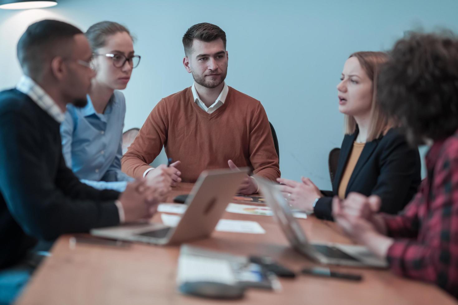 riuscito squadra. gruppo di giovane multietnico attività commerciale persone Lavorando e comunicare insieme nel creativo ufficio. selettivo messa a fuoco foto