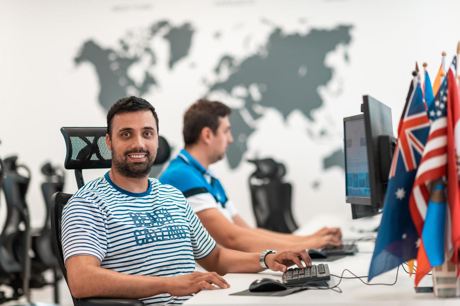 gruppo di casuale attività commerciale uomo Lavorando su del desktop computer nel moderno Aperto Piano avviare ufficio interno. selettivo messa a fuoco foto