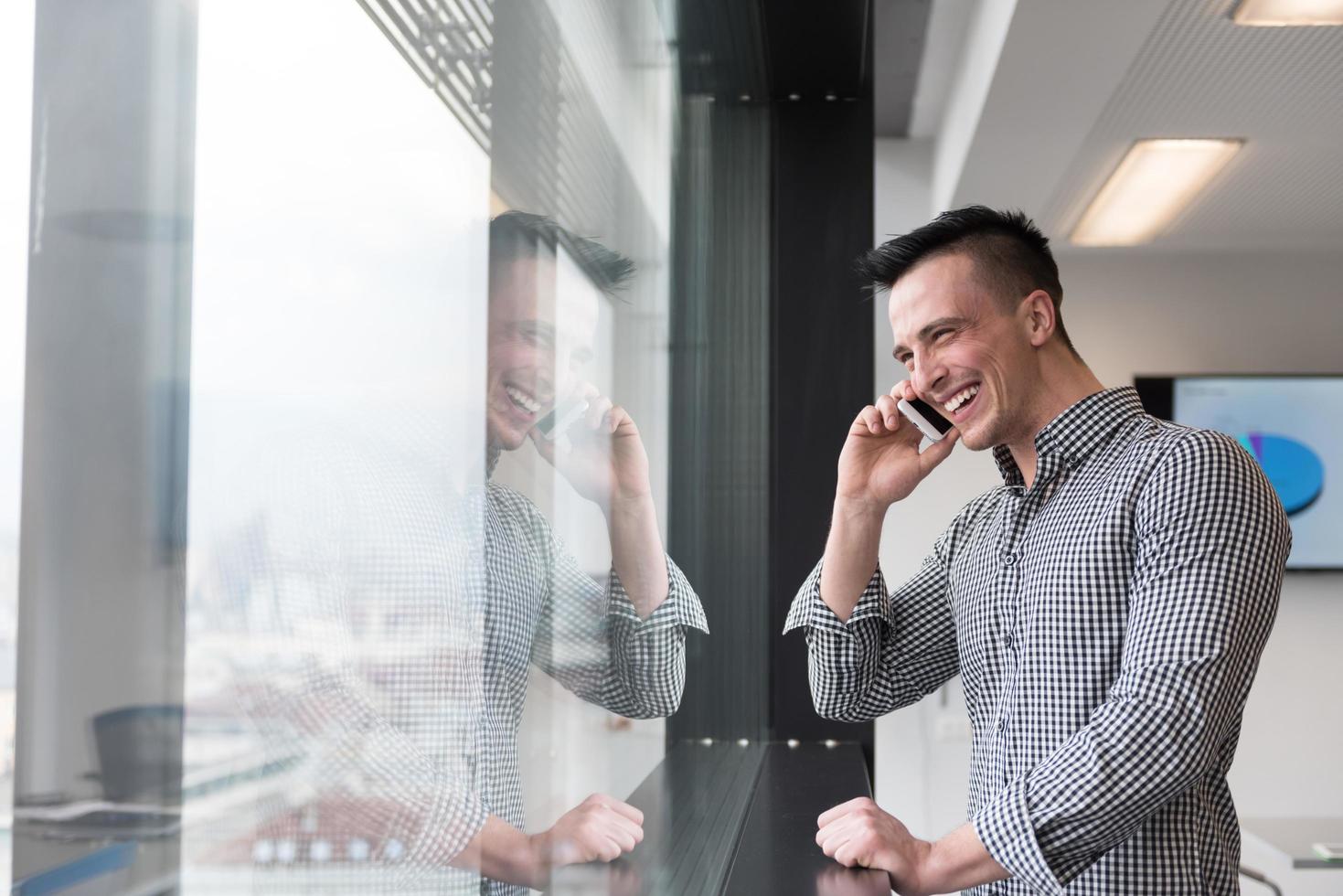 giovane attività commerciale uomo A proposito di su inteligente Telefono a ufficio foto