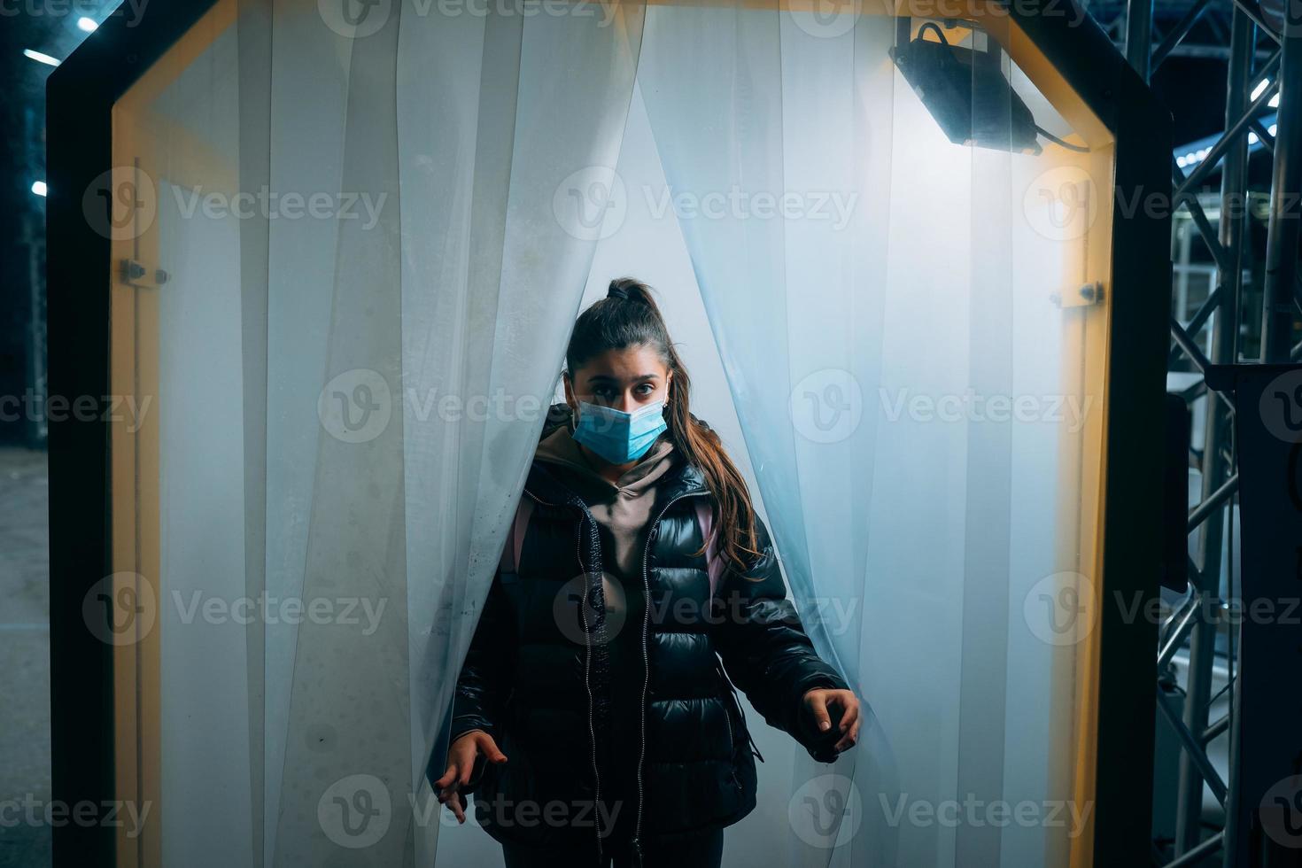 donna a medico maschera è soggiorno nel un' disinfezione tunnel foto