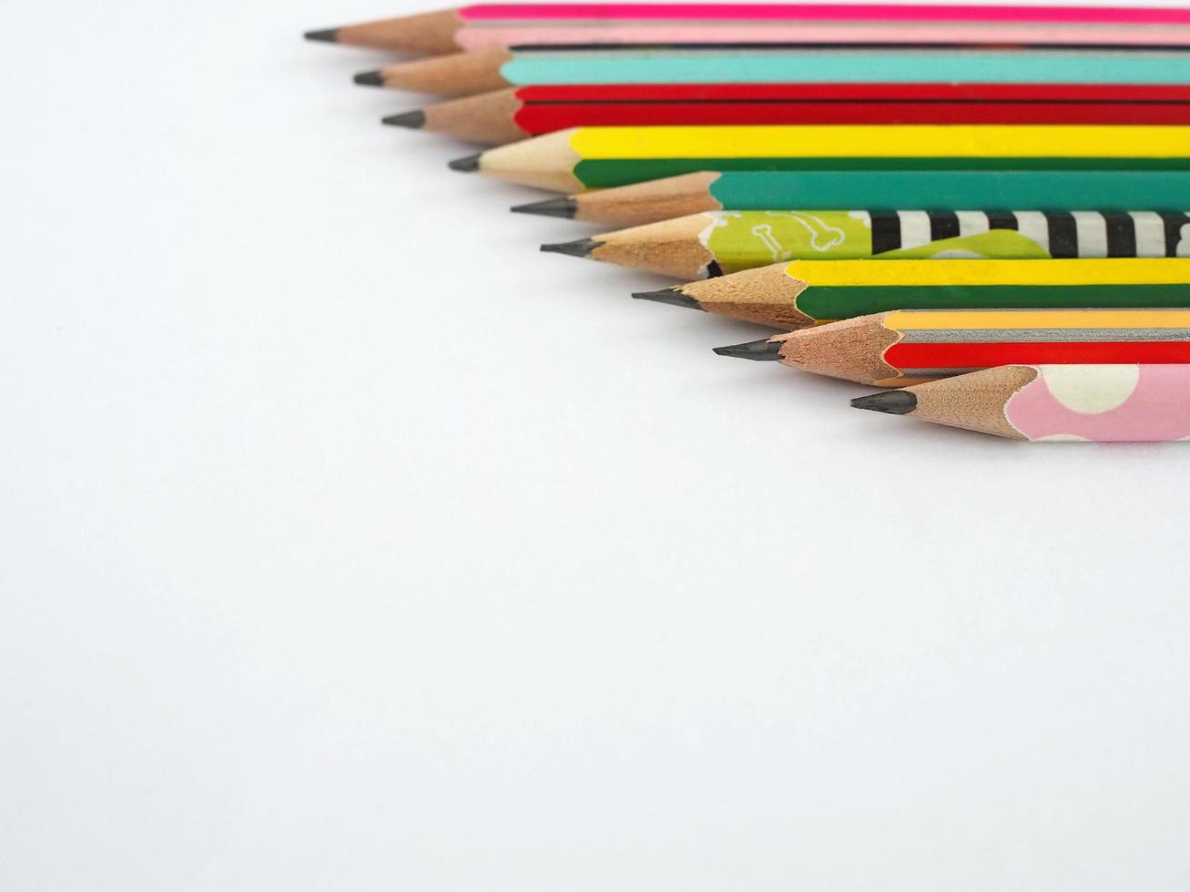 un' matita disposte nel un' riga su un' bianca sfondo foto