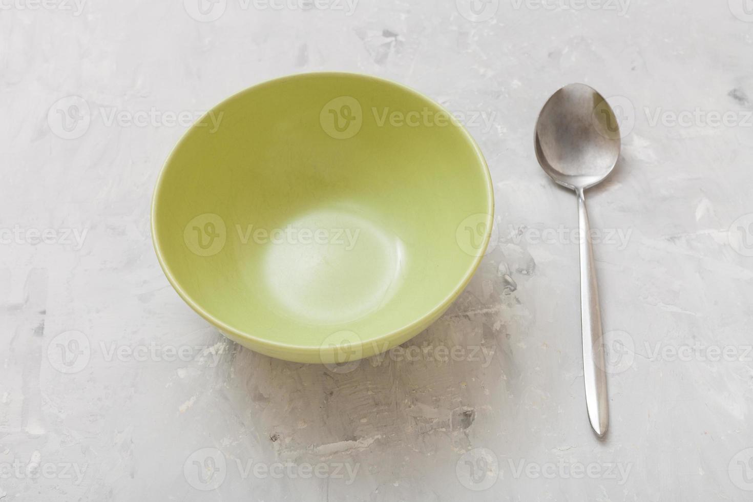 verde ciotola e cucchiaio su grigio calcestruzzo piatto foto