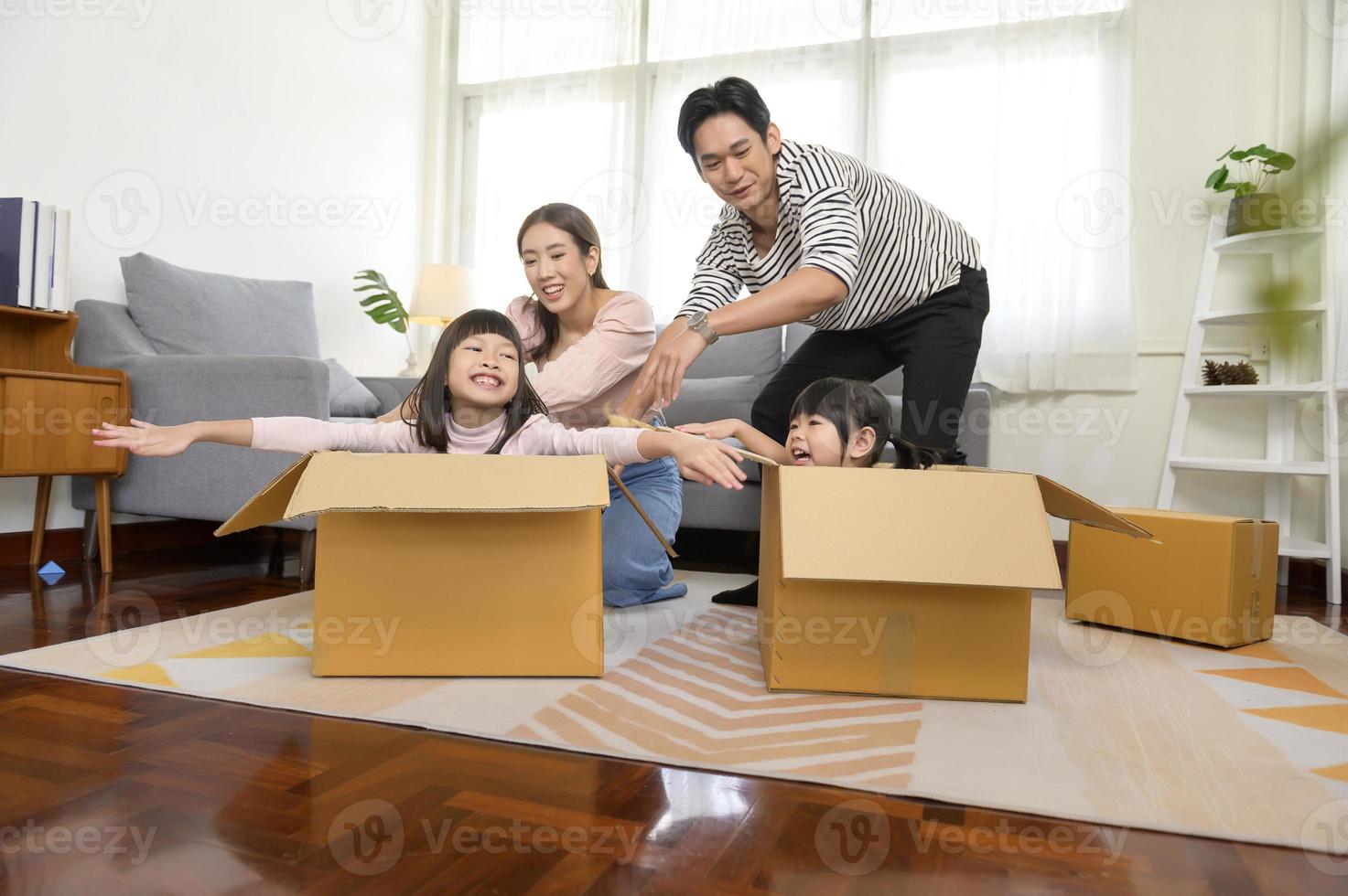 asiatico famiglia marito e moglie e bambini con cartone scatole avendo divertimento su in movimento giorno, mutuo, prestito, proprietà e assicurazione concetto. foto