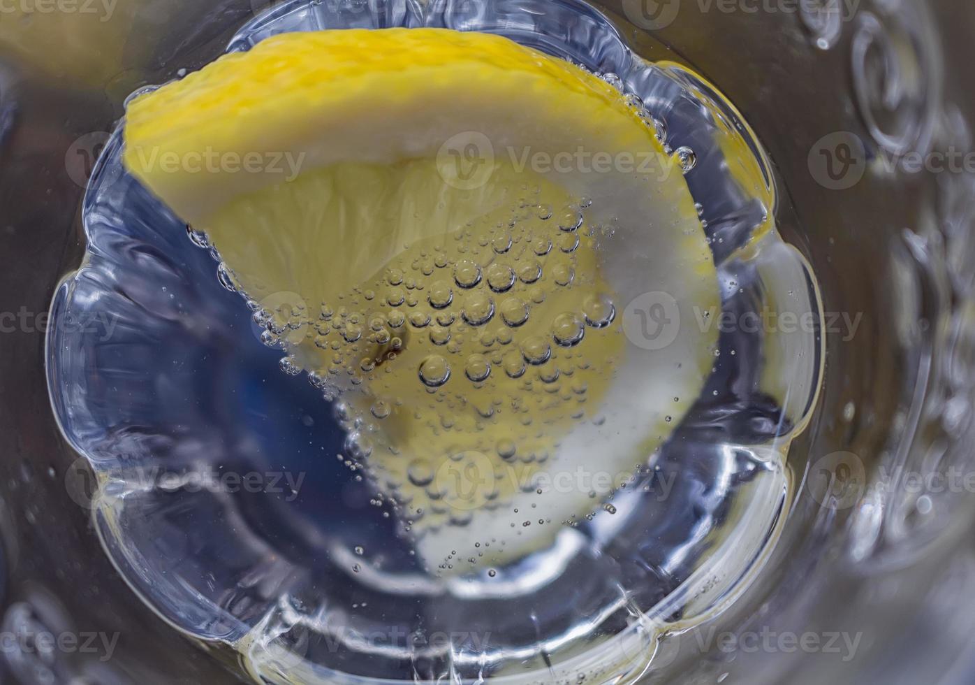 un' fetta di Limone immerso nel scintillante acqua. vicino su foto