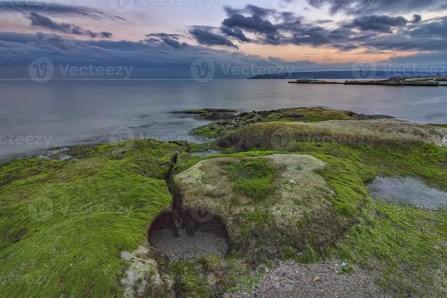 verde pomeriggio. roccioso spiaggia paesaggio marino a tramonto. foto