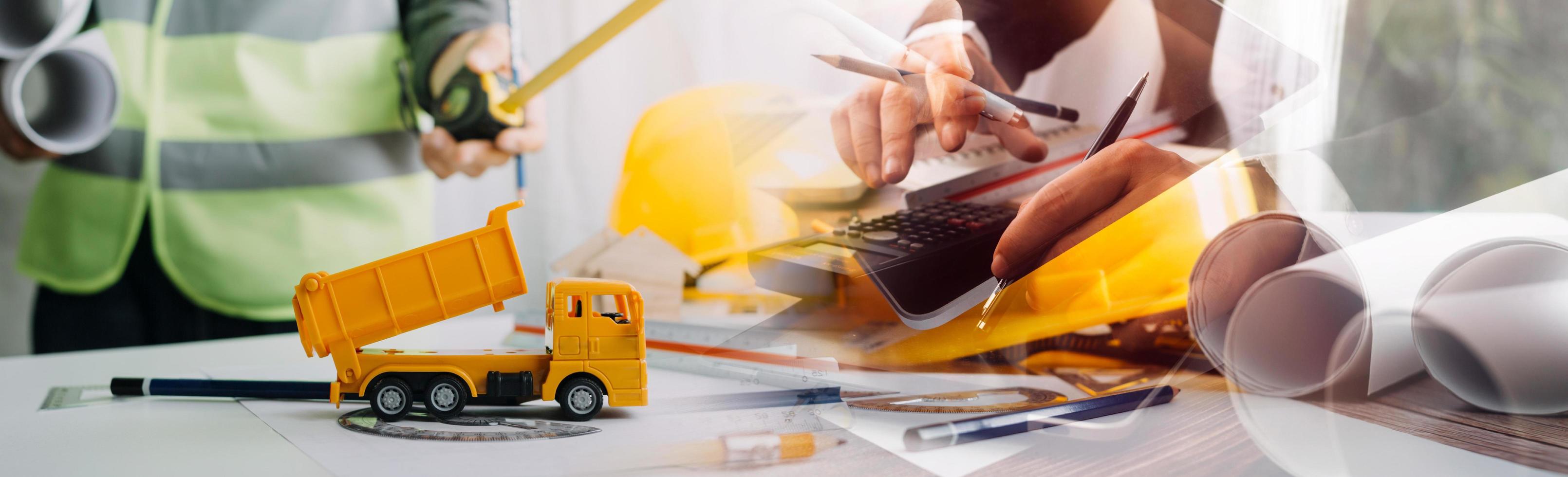 due colleghi che discutono di dati di lavoro e tablet, laptop con sul progetto architettonico in cantiere alla scrivania in ufficio foto