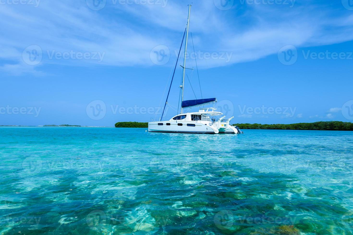 catamarano ancorato vicino a un'isola tropicale dei Caraibi foto