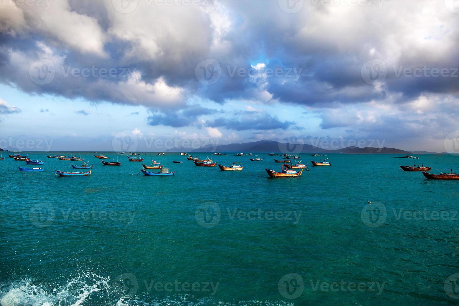 barche da pesca sul mare, uno sfondo di montagne foto