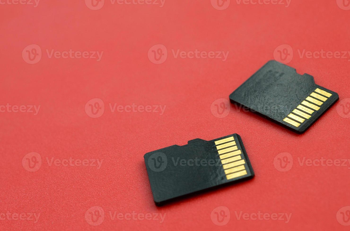 Due piccolo micro sd memoria carte menzogna su un' rosso sfondo. un' piccolo e compatto dati e informazione memorizzare foto