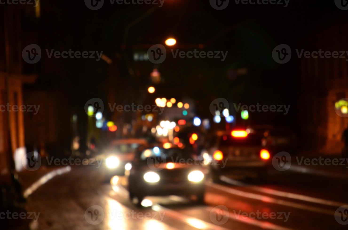 sfocato notte scena di traffico su il carreggiata. sfocato Immagine di macchine in viaggio con luminoso fari. bokeh arte foto