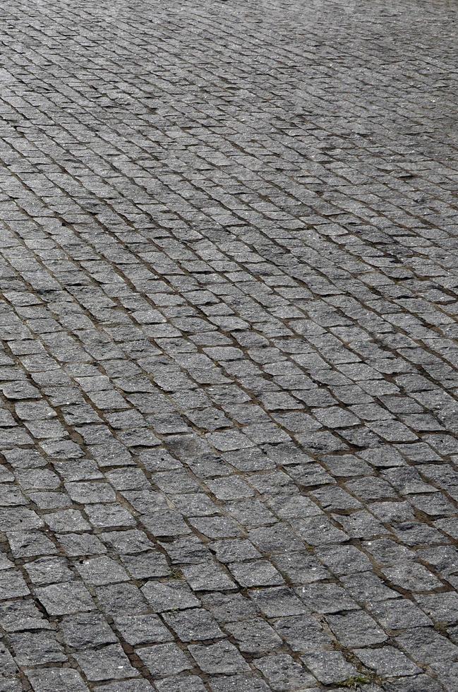 il struttura di il pavimentazione lastra pavimentazione pietre di molti piccolo pietre di un' piazza forma sotto luminosa luce del sole foto