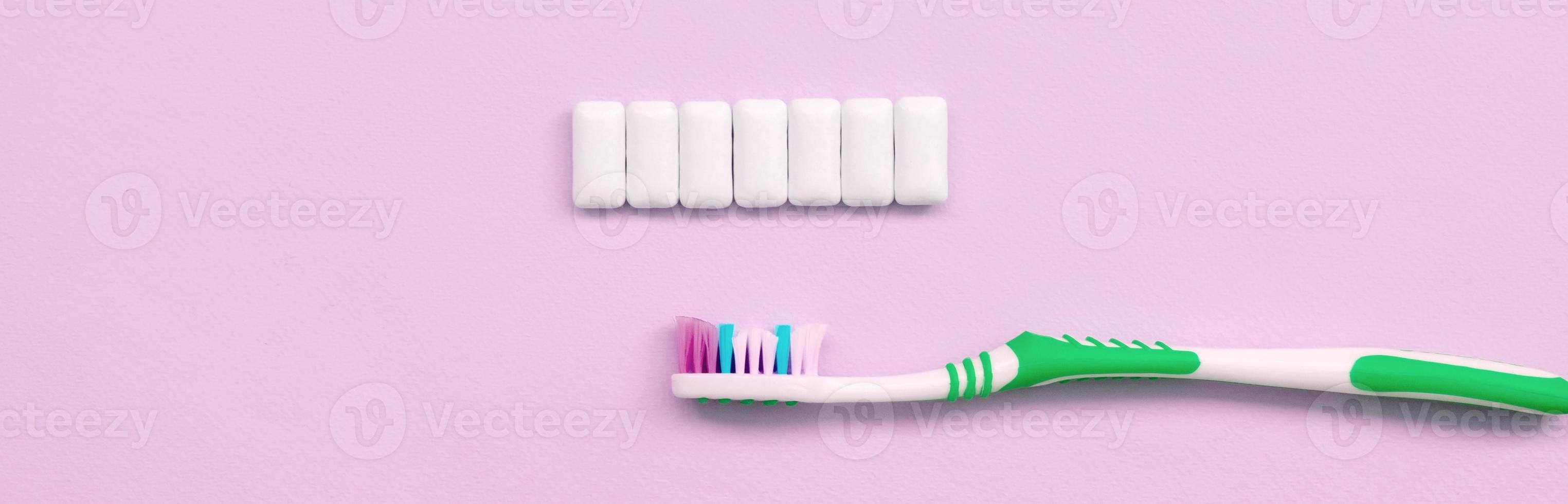 spazzolino e masticazione gengive menzogna su un' pastello rosa sfondo foto