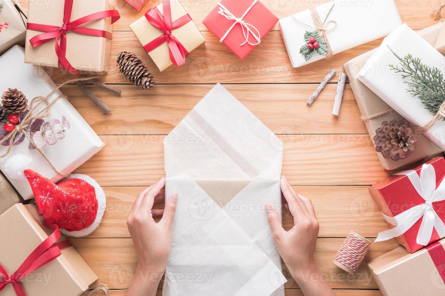 mano siamo involucro i regali di il allegro Natale e contento nuovo anno decorazione per celebrazione su legna sfondo con copia spazio foto