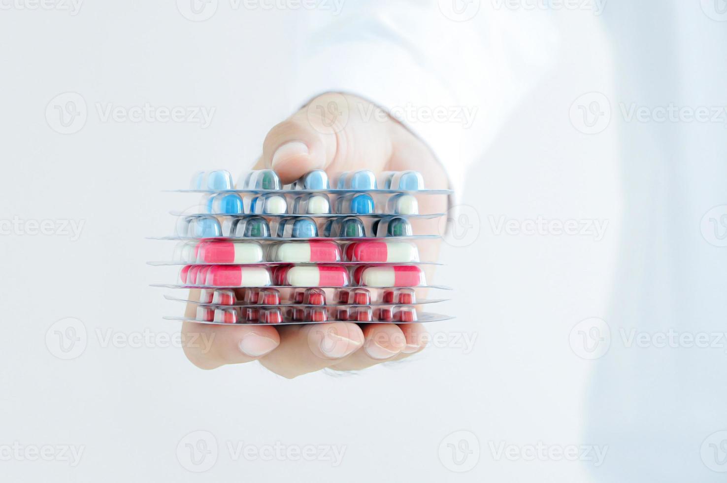 mano che dà medicine - capsule o pillole in confezioni blister foto