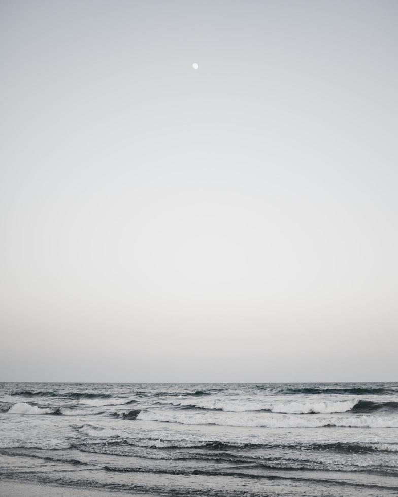 onde del mare e cielo grigio foto