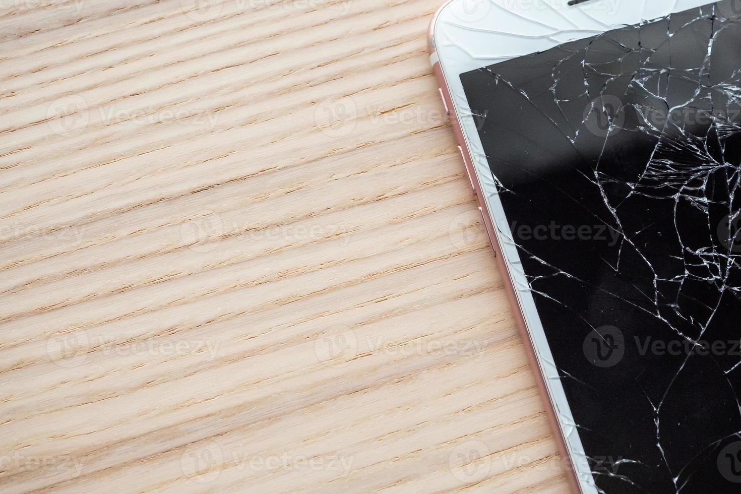 rotto bicchiere di mobile Telefono schermo su di legno sfondo foto
