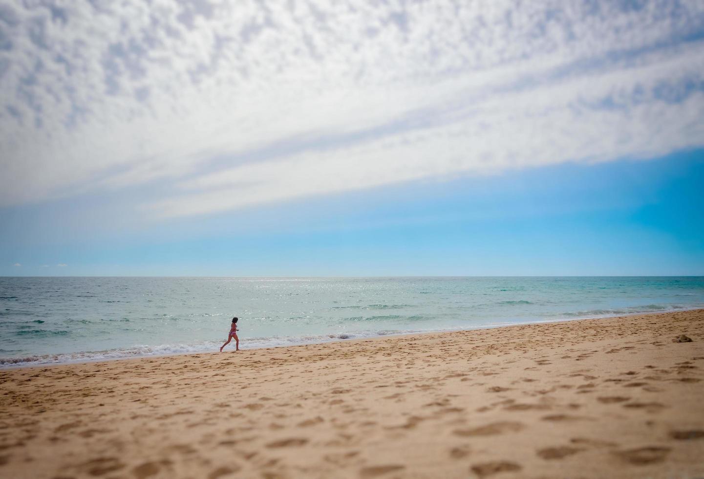 persona sola che corre sulla spiaggia foto