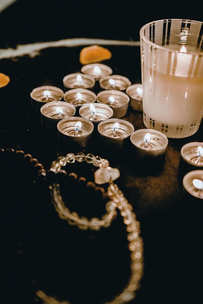 candele accese e rosario sul tavolo foto