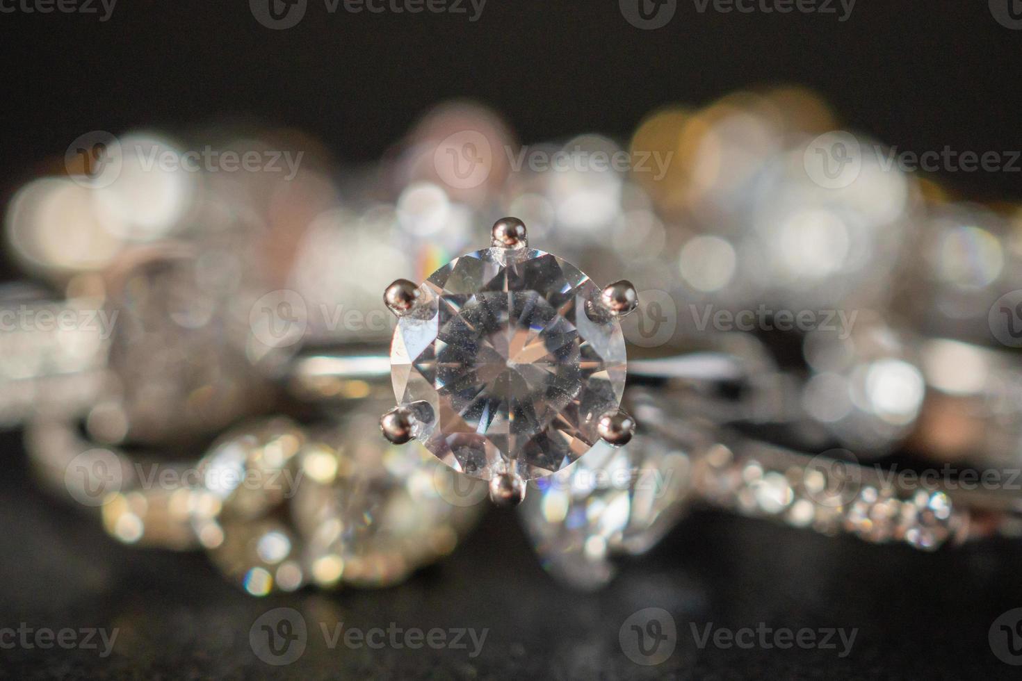 anelli di diamanti gioielli incastonati su sfondo nero da vicino foto