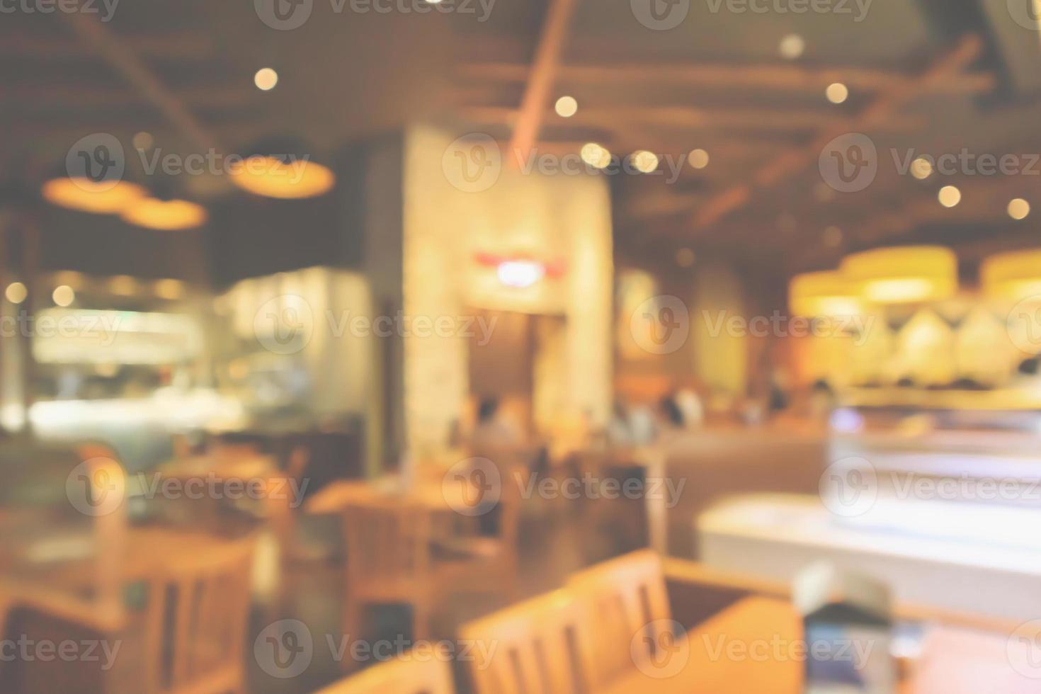 l'interno del ristorante con il cliente e il tavolo in legno sfocano lo sfondo astratto con luce bokeh foto