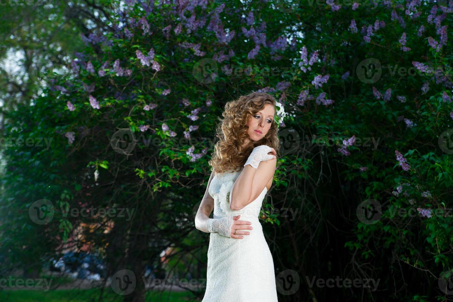 bella sposa in abito bianco su sfondo lilla foto