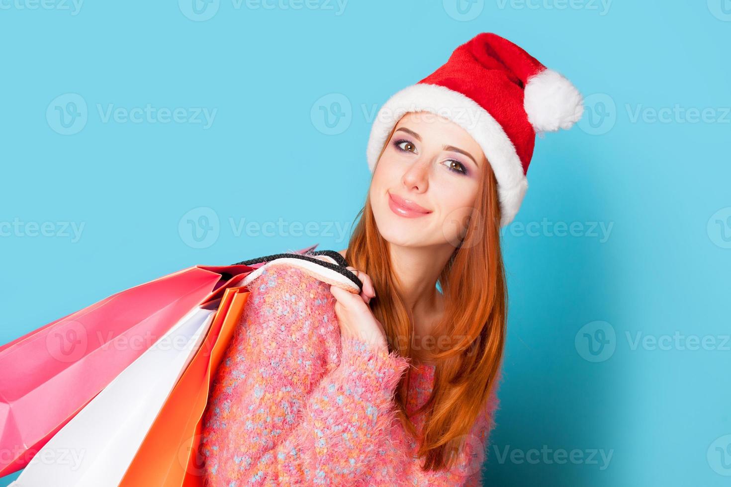 ragazza rossa con borse della spesa su sfondo blu. foto