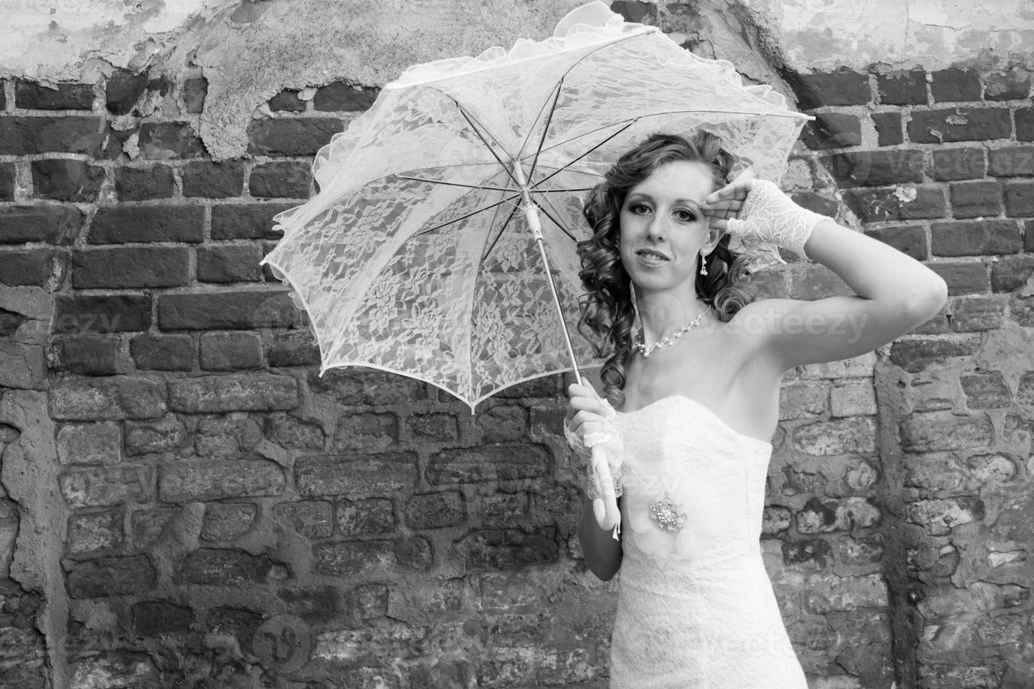 bella sposa in abito bianco con ombrellone foto