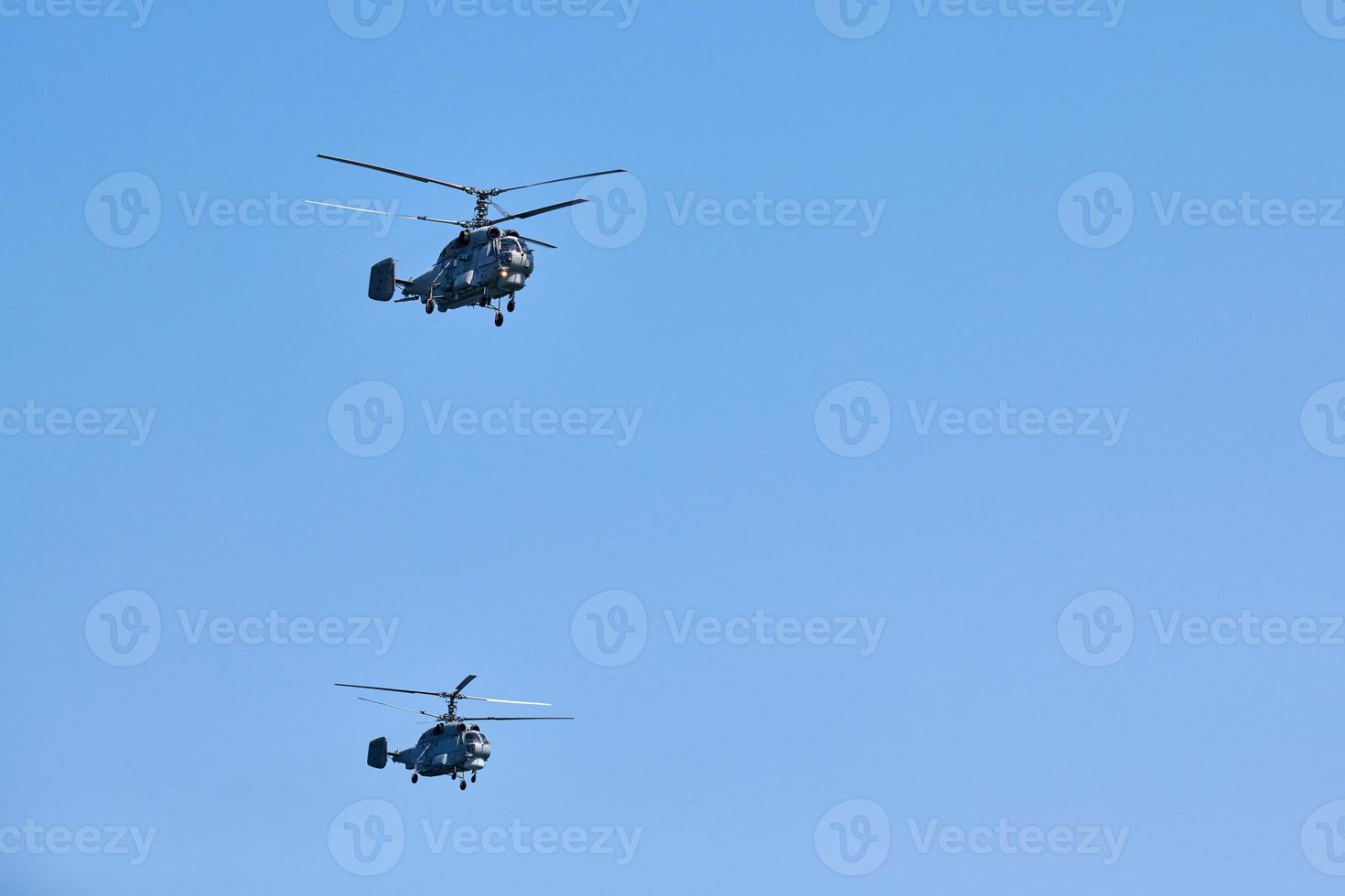 Due militare elicotteri volante nel vivace blu cielo l'esecuzione dimostrazione volo, aria mostrare foto