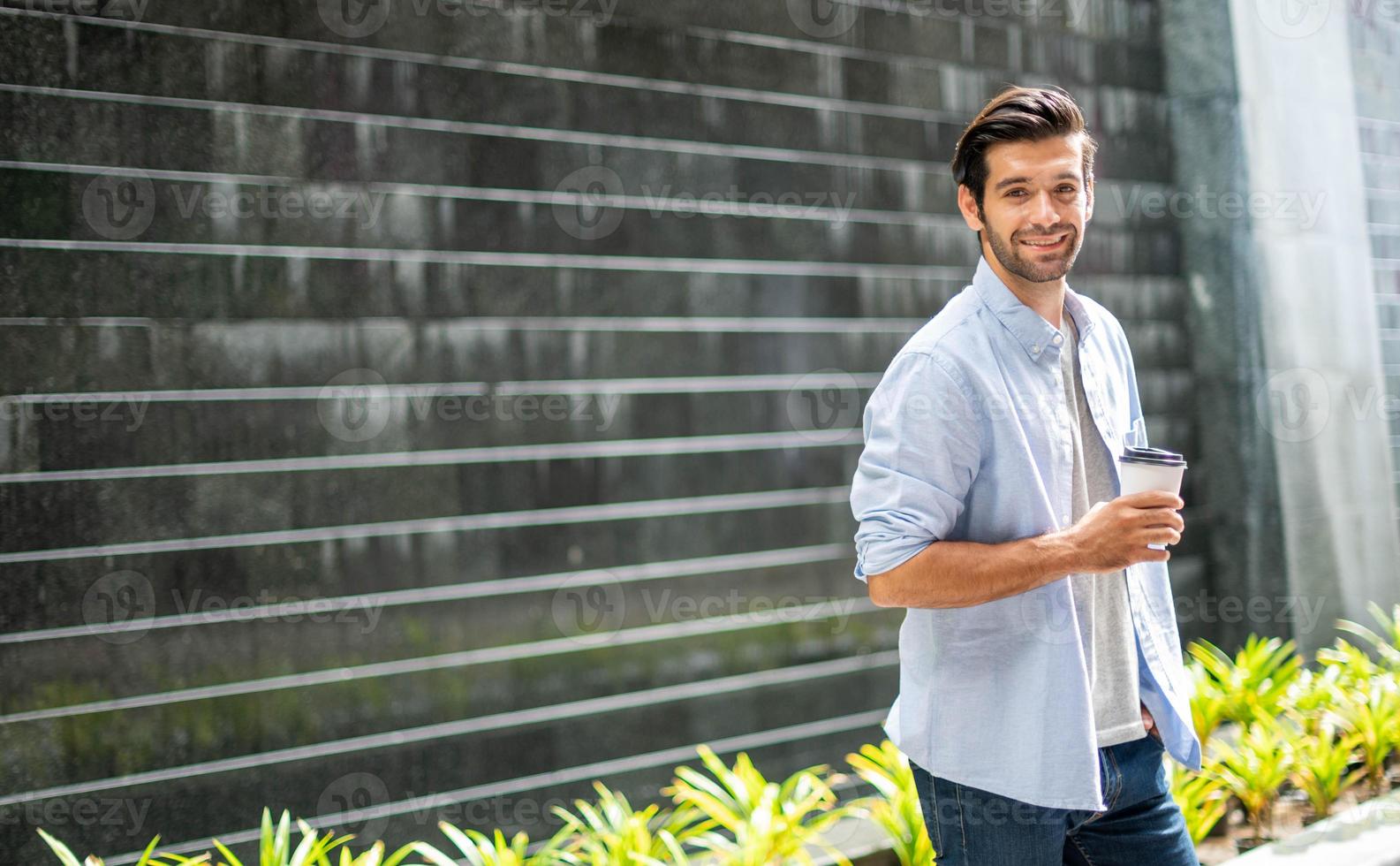 giovane caucasico uomo potabile caffè e indossare casuale camicia mentre a piedi su il suo modo per rilassare su il suo vacanza. foto