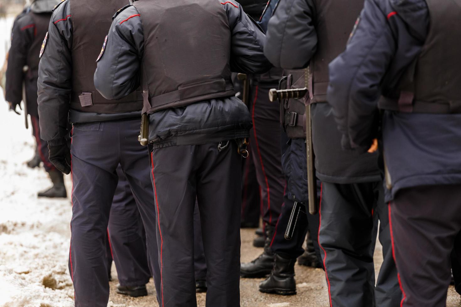 tula, Russia gennaio 23, 2021 folla di polizia ufficiali nel nero uniforme con antiproiettile giubbotti e pistole - Visualizza a partire dal Indietro. foto