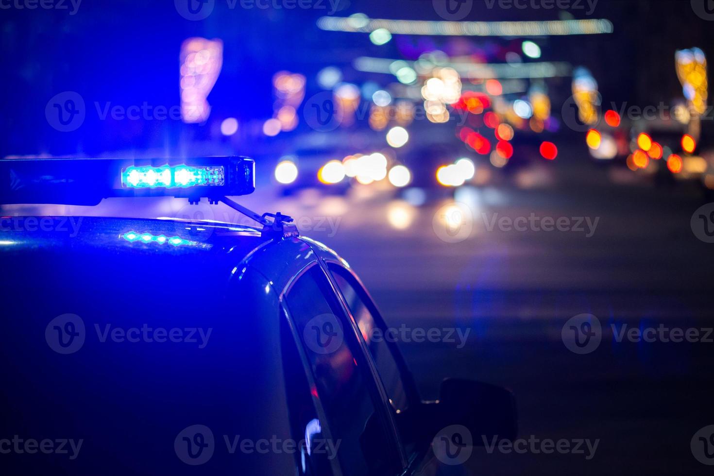polizia auto luci a notte nel città con selettivo messa a fuoco e bokeh foto